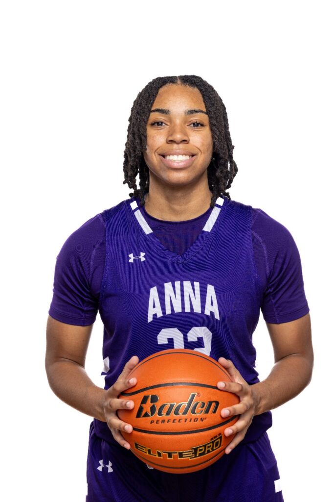 Girls basketball player in a purple Anna jersey holding a basketball against a white background