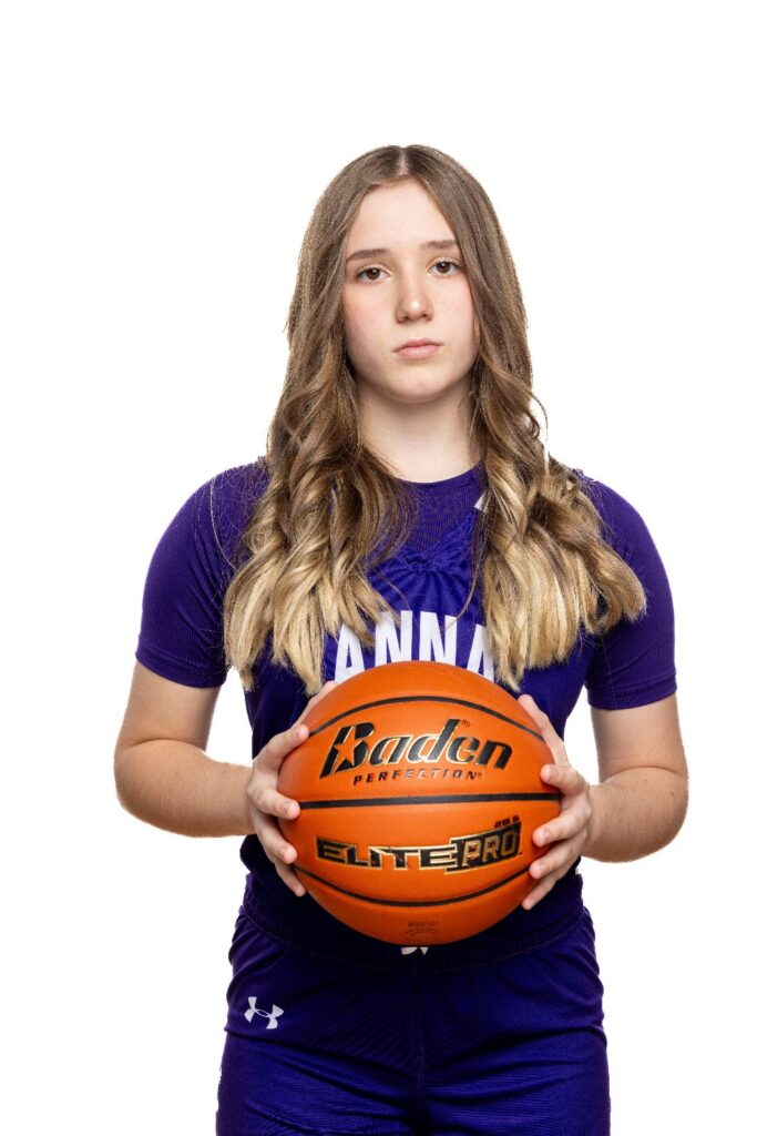 Girls basketball player in a purple Anna jersey holding a basketball against a white background